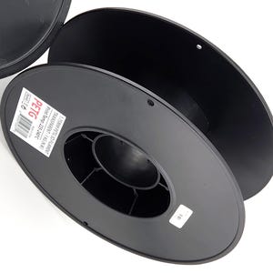 May include: Black 3D printer filament spools. One spool is partially open, revealing the interior structure. The label reads "PETG" and "1.75MM PETG 3D FILAMENT". The print temperature is listed as 225-240°C.