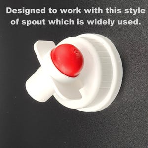 May include: White plastic bottle spout with a red push-down button. The spout is designed to fit a standard bottle.