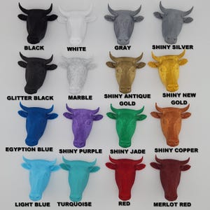 May include: A set of 14 bull head wall decor pieces in various colors and finishes, including black, white, gray, shiny silver, glitter black, marble, shiny antique gold, shiny new gold, Egyptian blue, shiny purple, shiny jade, shiny copper, light blue, turquoise, red, and merlot red.