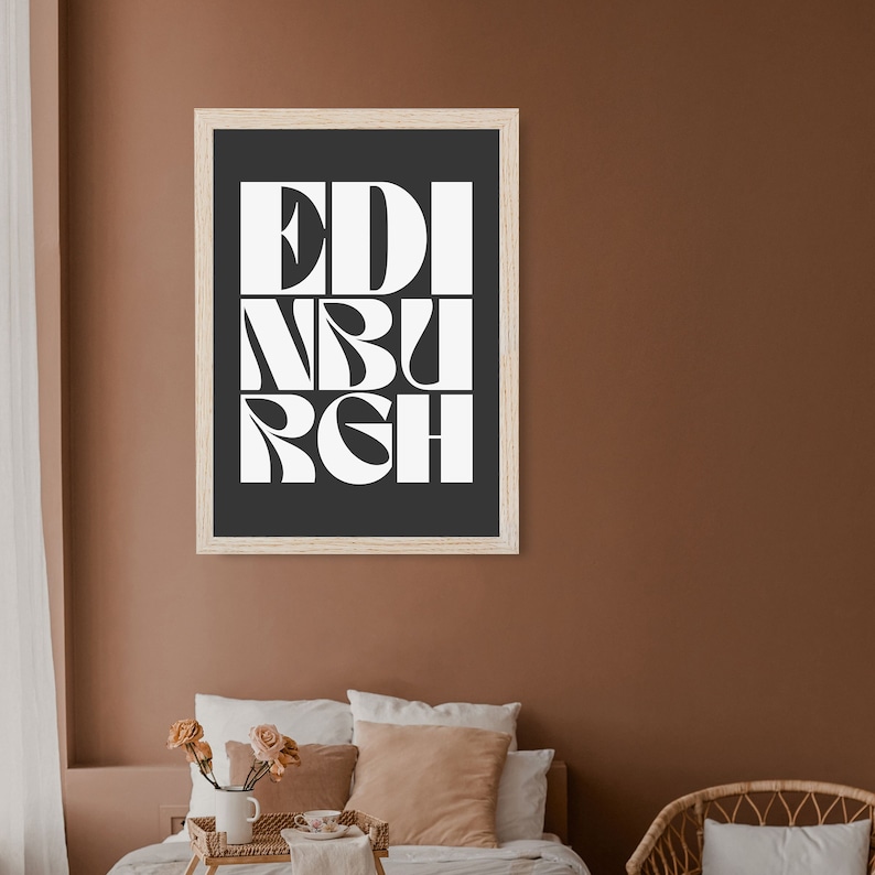 May include: A framed print with a black background and white text that reads "EDINBURGH" in a stylized font.
