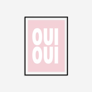 May include: A framed pink poster with the word "OUI" repeated twice in white, in a bold, blocky font.