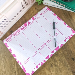 Könnte beinhalten: Ein rosa-weißer Wochenplaner mit Kuhmuster. Der Planer hat Platz für jeden Tag der Woche mit Abschnitten für "Prioritäten" und "To Do".
