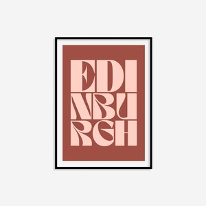 May include: A framed print with a red background and the word "EDINBURGH" in pink letters. The letters are stylized and overlap each other.