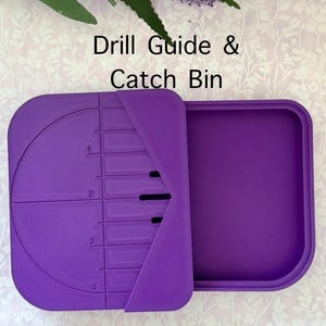 Puede incluir: Guía de perforación y contenedor de recogida de plástico morado con una guía circular y ranuras numeradas para brocas. El texto "Drill Guide & Catch Bin" está impreso en la parte superior de la imagen.