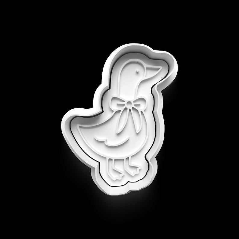 May include: White plastic cookie cutter in the shape of a goose wearing a bow tie. The goose has a detailed outline with a beak, eye, and feet. The cookie cutter is on a black background.