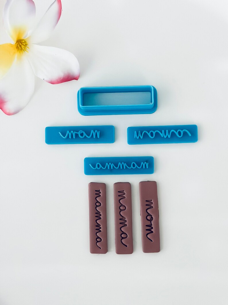 May include: A set of blue and brown polymer clay stamps for baking and crafting. The stamps feature the words "mom", "mamma", and "mama" in a handwritten font. There is also a blue rectangle stamp with a wavy line design.