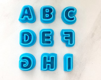 May include: Nine blue plastic cookie cutters shaped like the letters A through I.