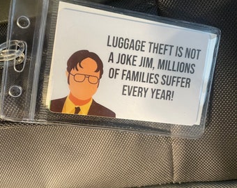 May include: A white luggage tag with a cartoon image of a man with glasses and a tie. The text on the tag reads "LUGGAGE THEFT IS NOT A JOKE JIM, MILLIONS OF FAMILIES SUFFER EVERY YEAR!"