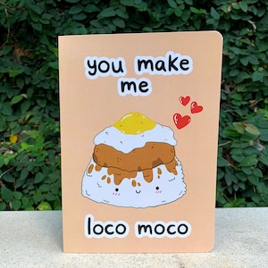 May include: A pink card with the text "you make me loco moco" and a cartoon illustration of a loco moco dish with a smiling face.