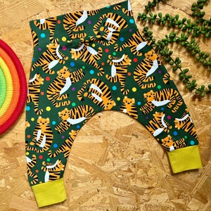May include: Green and yellow baby trousers with a tiger print and colourful polka dots.