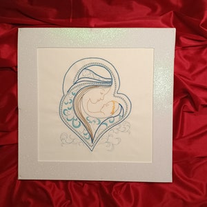 Könnte beinhalten: Eine weiße gerahmte Stickerei, die eine Mutter und ein Kind in Herzform zeigt. Die Stickerei ist in blauer, goldener und weißer Farbe ausgeführt.