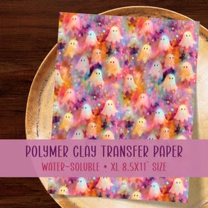 May include: A sheet of water-soluble polymer clay transfer paper featuring a repeating pattern of small ghosts and stars in vibrant shades of orange, pink, purple, and yellow. The text reads POLYMER CLAY TRANSFER PAPER WATER-SOLUBLE XL 8.5X11 SIZE.