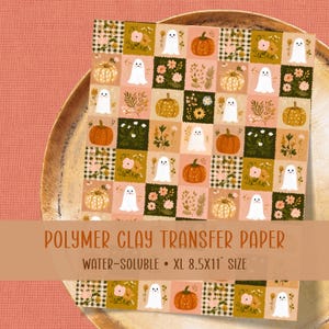 Könnte beinhalten: Ein wasserlösliches Polymer-Ton-Transferpapier im Format 21,6x27,9 cm mit einem sich wiederholenden Gittermuster aus weißen Geistern, orangefarbenen Kürbissen und verschiedenen Blumenarrangements in Rosa, Gelb und Grün auf kariertem Grund.