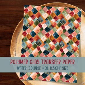 May include: A sheet of polymer clay transfer paper featuring a repeating diamond pattern in shades of deep blue, forest green, mustard yellow, and soft pink, with gold botanical accents. The text reads POLYMER CLAY TRANSFER PAPER WATER-SOLUBLE XL 8.5X11 SIZE.