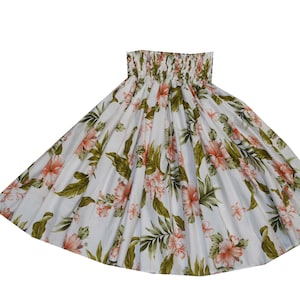 Op de afbeelding: Witte rok met een bloemenpatroon met roze en oranje bloemen en groene bladeren. De rok heeft een gerimpelde tailleband en een vloeiend, uitlopend ontwerp. De stof lijkt licht en geschikt voor warm weer.