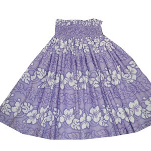 Op de afbeelding: Een lavendelkleurige en witte bloemenprint rok. De rok heeft een gerimpelde, elastische tailleband en een volle, vloeiende silhouet. De stof is bedrukt met witte hibiscusbloemen en andere tropische motieven.