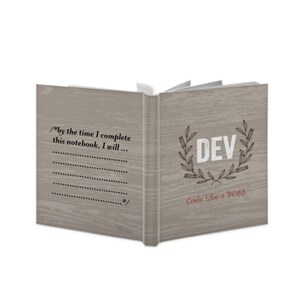 Op de afbeelding: Een grijs notitieboek met een houtnerfstructuur. De voorkant heeft een krans met het woord "DEV" in het midden en de tekst "Code Like a BOSS" eronder. De achterkant heeft de tekst "/*by the time I complete this notebook, I will... */" en een geruimete ruimte om te schrijven.