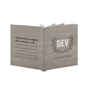 Op de afbeelding: Een grijs notitieboek met een houtnerfstructuur. De voorkant heeft een krans met het woord "DEV" in het midden en de tekst "Code Like a BOSS" eronder. De achterkant heeft de tekst "/*by the time I complete this notebook, I will... */" en een geruimete ruimte om te schrijven.
