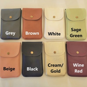 May include: Eight different colored phone pouches with a flap and a button closure. The pouches are arranged in two rows of four. The colors are grey, brown, white, sage green, beige, black, cream/gold, and wine red.