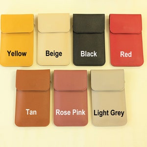 May include: Seven different colored phone pouches with a flap closure. The pouches are in the colors yellow, beige, black, red, tan, rose pink, and light grey. Each pouch has the color name printed on the front.