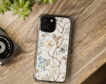 May include: A clear phone case with a floral design. The case has a white background with brown vines and blue, white, and yellow flowers.