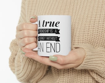 May include: White ceramic mug with black text that reads "A true friendship is a journey without an end".