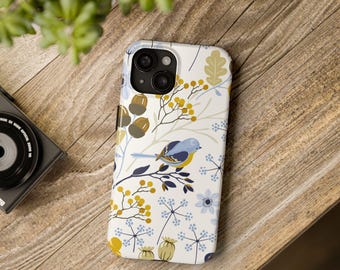 May include: A white phone case with a floral pattern featuring blue birds, yellow berries, and brown acorns. The case has a camera lens cutout.