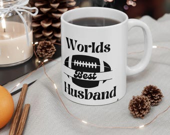 May include: White ceramic coffee mug with a black football graphic and the text "Worlds Best Husband".