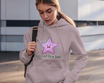 May include: A light pink hoodie with a cartoon starfish and the text "under the sea".