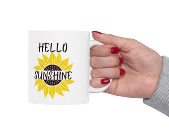 May include: White ceramic mug with a black and yellow sunflower graphic and the text "HELLO SUNSHINE".