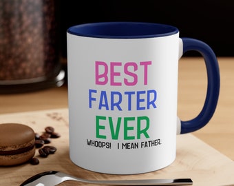 May include: White ceramic coffee mug with a blue rim and handle. The mug has a humorous saying in pink, blue, and green text: "Best Farter Ever Whoops! I mean Father."