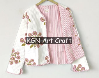 May include: A reversible, quilted jacket with a floral pattern. The jacket features a white exterior with pink floral embroidery and a red and white striped interior. The jacket is hanging on a wooden hanger against a white wall. The text "KGN Art Craft" is visible.
