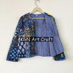 Può includere: Una giacca in patchwork blu e bianco con fodera a righe. La giacca ha una chiusura con bottoni e maniche lunghe. Il testo "KGN Art Craft" è visibile sul davanti della giacca.