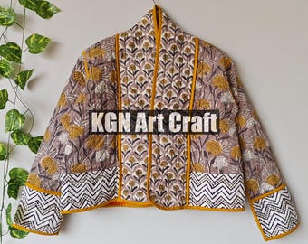 May include: A quilted jacket with a floral pattern in shades of brown, yellow, and white. The jacket has a yellow trim and a zigzag pattern on the cuffs. The text "KGN Art Craft" is visible on the jacket.