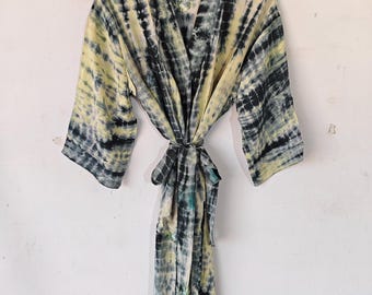 Könnte beinhalten: Eine lange, schwarz-gelbe Batik-Robe mit einem Bindegürtel. Die Robe ist aus einem weichen, fließenden Stoff.