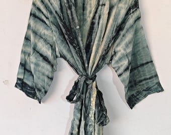 Könnte beinhalten: Eine lange, grün-weiße Batik-Robe mit einem Selbstgürtel. Die Robe hat eine lockere Passform und einen V-Ausschnitt.