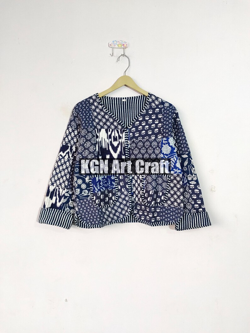May include: A blue and white patterned cotton jacket with a V-neck and long sleeves. The jacket is made of patchwork fabric and has a button closure. The text "KGN Art Craft" is visible on the front of the jacket.