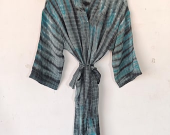 Könnte beinhalten: Eine lange, fließende Batik-Robe in Schwarz und Türkis. Die Robe hat einen Gürtel in der Taille und Dreiviertelärmel.