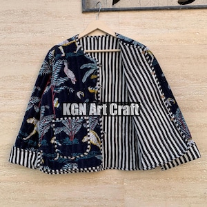 May include: A black and white striped reversible jacket with a floral print on one side. The jacket has a button closure and a pocket on the floral side. The text "KGN Art Craft" is visible on the jacket.