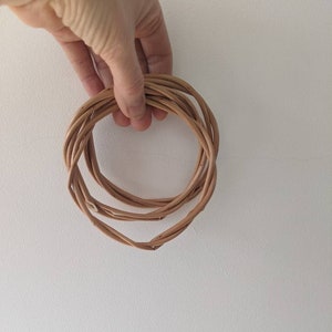 May include: A brown woven wreath made of natural materials.