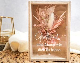 Puede incluir: Una caja de madera con un frente de vidrio que contiene flores secas y una inscripción blanca que dice "Glück ist... eine Mama wie dich zu haben".