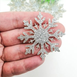 Peut inclure: Ornement flocon de neige en paillettes argentées. Le flocon de neige est une étoile à six branches avec une finition scintillante.
