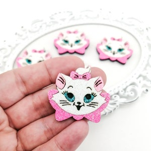 May include: A white glitter cat with pink ears, a pink bow, and blue eyes. The cat is wearing a pink collar and has a white face. The cat is made of wood and is decorated with glitter.