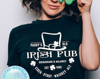 May include: A black t-shirt with a white graphic design of a leprechaun's hat with a shamrock on top. The text "Paddy's Old Irish Pub" is written in a white cursive font. Below the text is a shamrock and the text "Shenanigans & Malarkey". Below that is a shamrock and the text "Est. 1989". Below that is a shamrock and the text "Cider Stout Whiskey Ale".