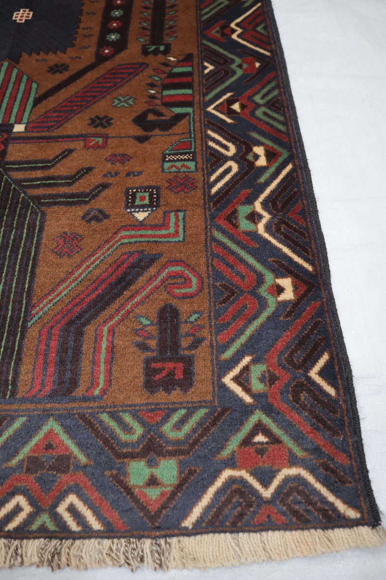 May include: Close-up of a brown, black, green and cream patterned rug with fringe. The rug has a geometric design with intricate details.