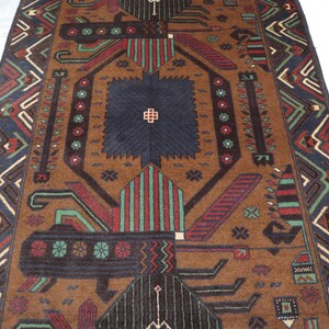 May include: A brown rug with a geometric pattern in shades of red, green, blue, and black. The rug has a central diamond shape with a smaller diamond inside. The rug has a border with a repeating pattern.
