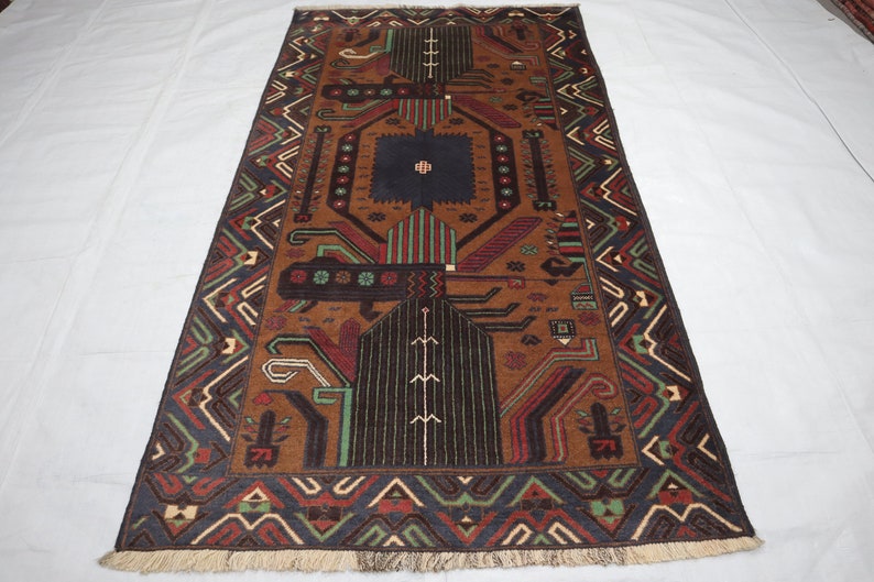 May include: A brown, blue, green and red patterned rug with a geometric design. The rug has a fringed border.