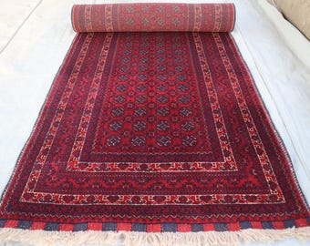 Puede incluir: Una alfombra roja y azul con un borde de flecos. La alfombra tiene un diseño tradicional con detalles intrincados.