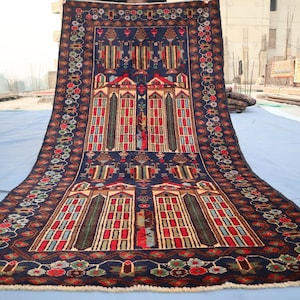May include: A traditional Persian rug with a dark blue background and intricate geometric patterns in red, green, and cream. The rug features a central design of three arched doorways with windows and a floral motif.