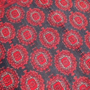 May include: A red and black rug with a repeating geometric pattern. The rug has a traditional design with intricate details.